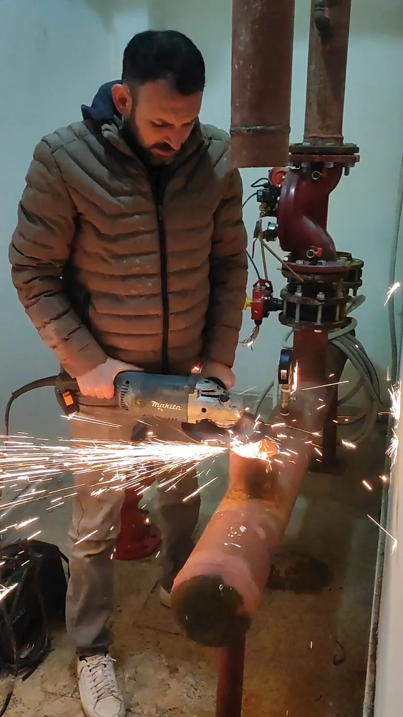 Metal boru hattı üzerinde çalışan tesisat ustası